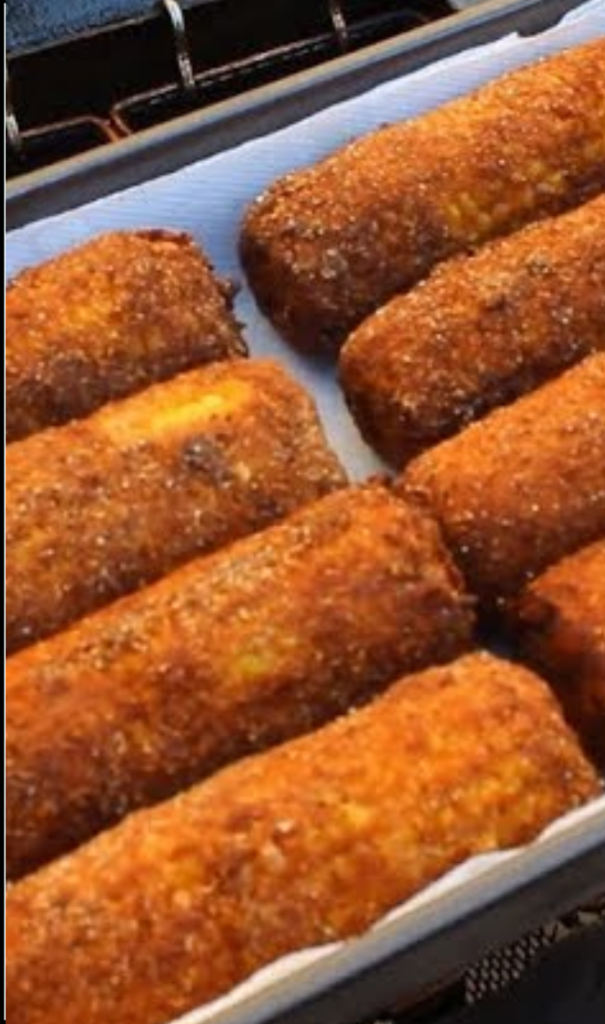 Air fried corn on the cob with a crispy cornmeal coating on a white plate.

