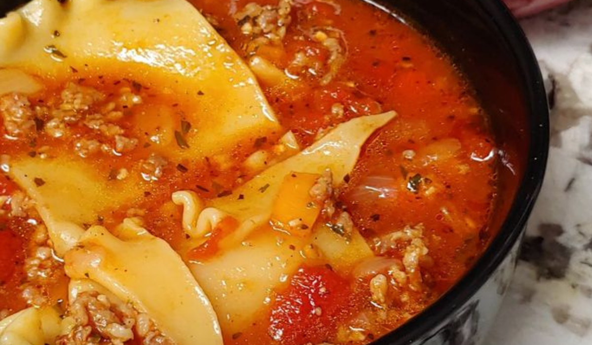 A bowl of Instant Pot Lasagna Soup, topped with ricotta cheese, fresh basil, and parmesan.